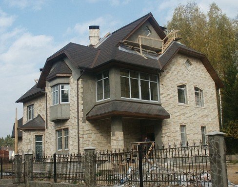 Двухэтажный дом из кирпича на 400 кв.м с фигурной крышей